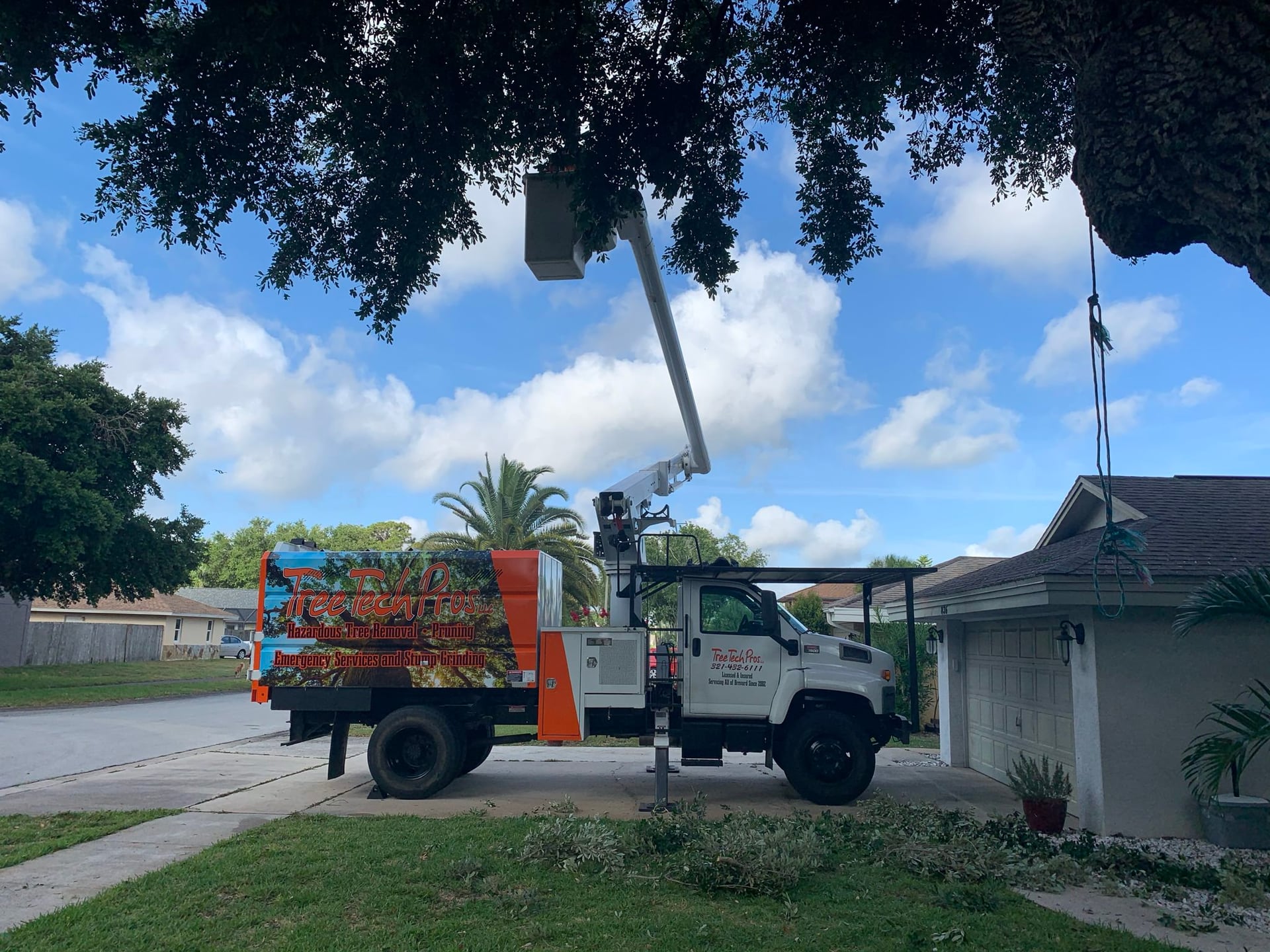 Tree Tech Pros bucket truck on a job in a Brevard County driveway