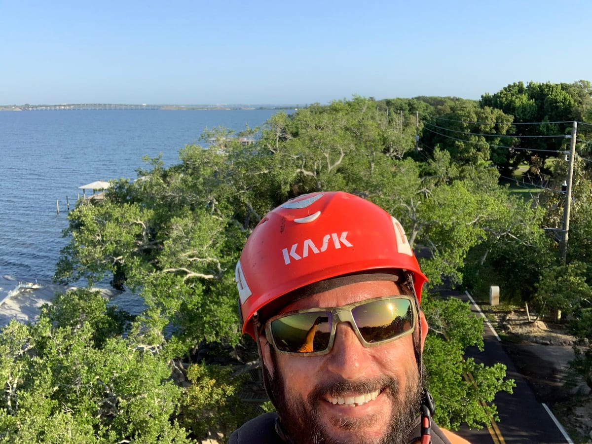 Crew member smiling with a waterfront view in the background